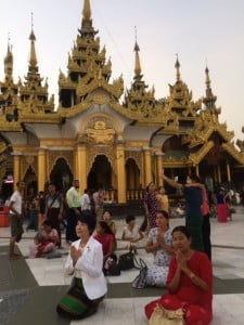 日曜の夕刻、金装飾に輝くパゴダ寺院内。自分が誕生した曜日の祭壇に置かれた仏像などに水をかけて祈る多くの人 々の姿がありました。私も、事前に調べた誕生日＝日曜日の神様の前で、祈りの儀式を行いました。